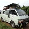 Safari van with tourists and guide posing safely during a Lake Nakuru National Park full-day tour — book today with park entry fees and tickets included
