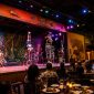 Colorful African dancers perform on stage during the Safari Cats Show in Nairobi, with guests enjoying dinner and watching the cultural performance under vibrant theatrical lighting.