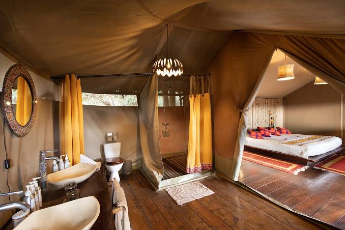 Luxury safari tent with an en-suite bathroom, king-size bedroom, and modern amenities at a Maasai Mara safari camp with Cruzeiro Safaris Kenya.