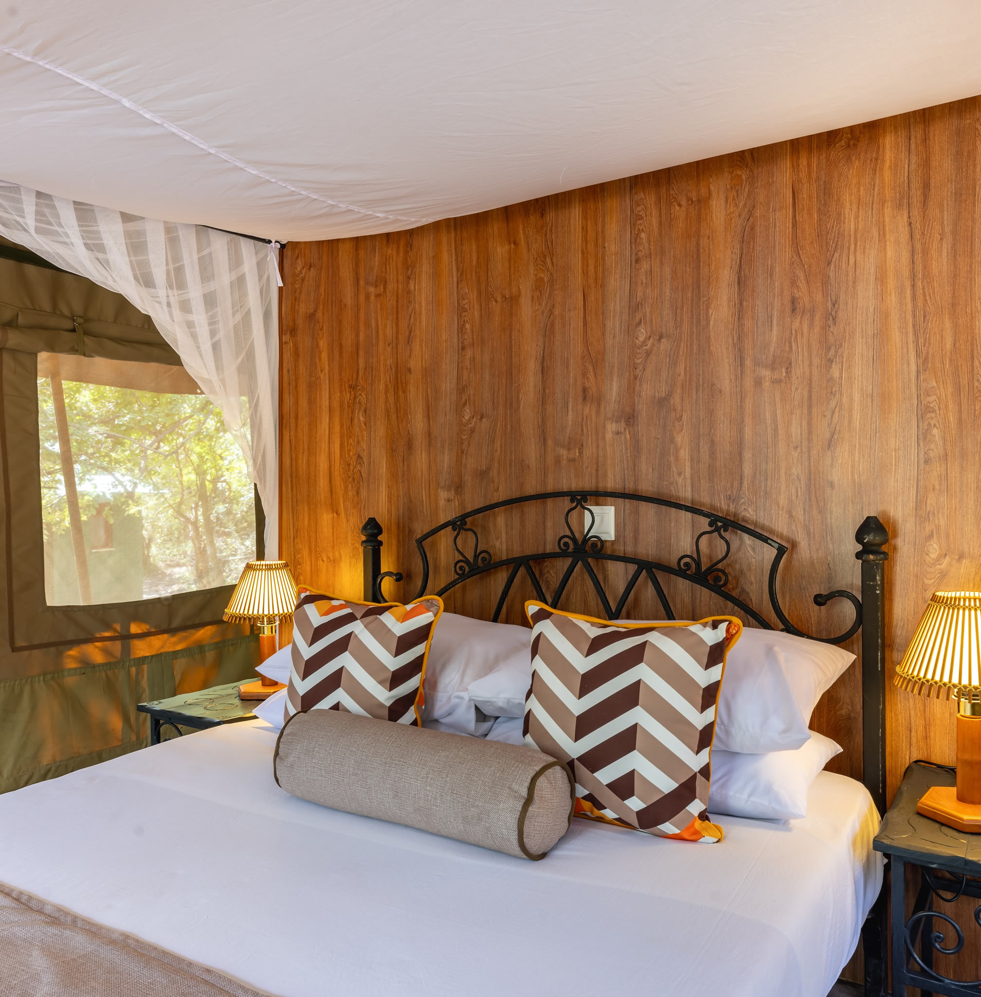Luxury king-size bed inside a premium safari tent at Sentrim Mara Camp in Maasai Mara, Kenya, offering elegant accommodation during a Kenya safari with Cruzeiro Safaris Kenya.