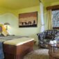 guest room at Mara Serena Safari Lodge featuring a king-size bed, African-inspired décor, lounge seating, and modern amenities in the Maasai Mara, Kenya.